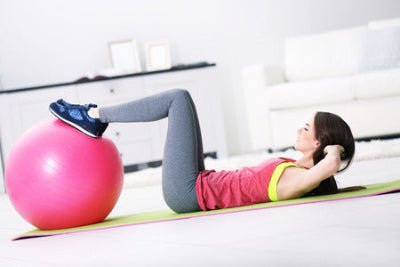 fille couchee sur dos avec un ballon de-gym rose